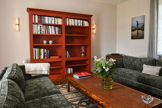 Le salon vert : canapés de velours vert et bibliothèque rouge